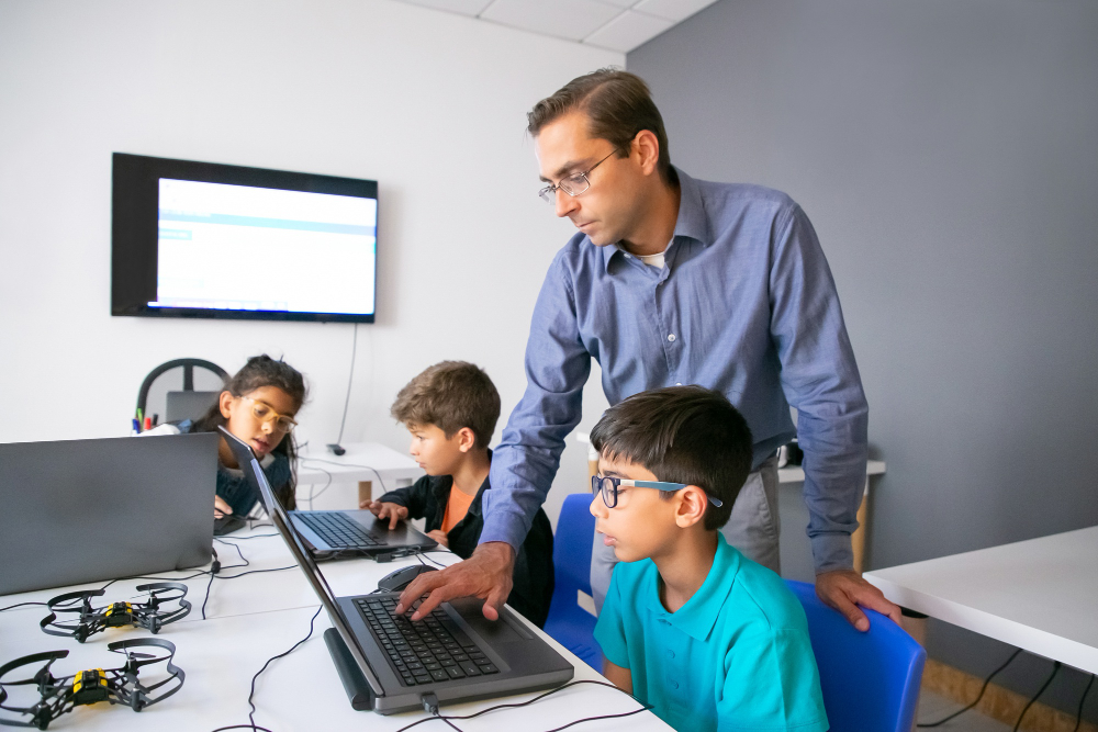 Professor ensinando aluno no computador sobre o uso da inteligência artificial