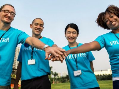 Pessoas com mãos juntas de camiseta azul