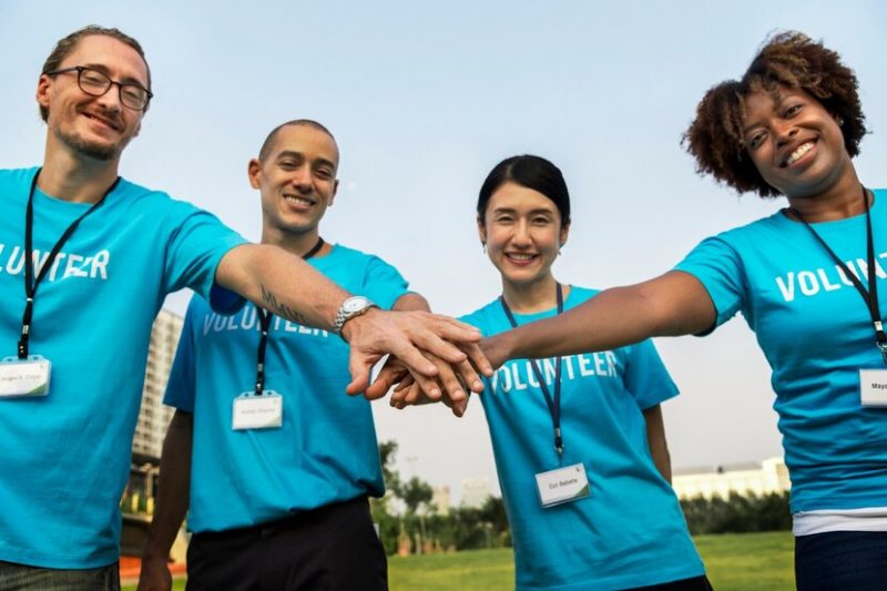 Pessoas com mãos juntas de camiseta azul