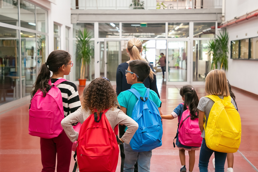 alunos entrando na escola com a professora